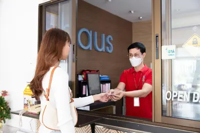 a woman in a mask is shaking hands with a man in a store at D-haus Ladprao Residence in Bangkok