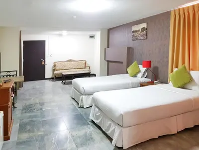a hotel room with two beds and a couch at D-haus Ladprao Residence in Bangkok