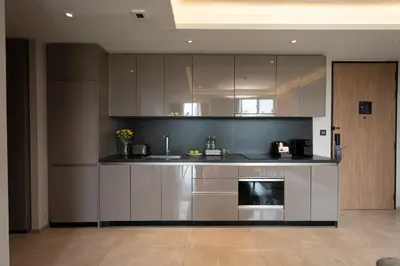 a kitchen with stainless steel cabinets and a stove at Walton Suites Sukhumvit in Bangkok