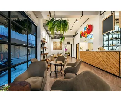 a lobby of a restaurant with chairs and a bar at Siam Subway Hostel and Café in Bangkok