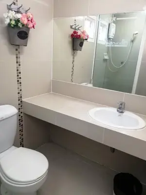 a bathroom with a sink and a toilet and a mirror at ruamsab apartment1 in Bangkok