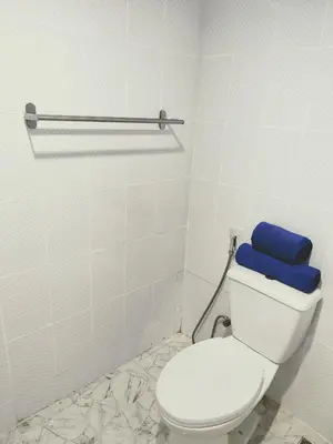 a bathroom with a toilet with a blue pillow on it at Lumphini 9 Haven Urban Retreat Bright Room in Bangkok