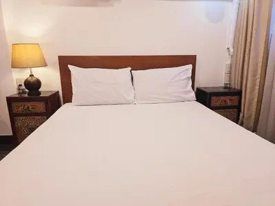 a bedroom with a white bed with two night stands at Old Sрice 2 Urban Studio Oasis Central Bangkok MRT in Bangkok