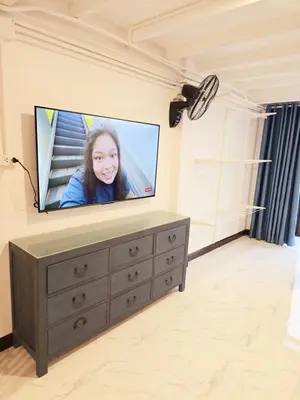 a living room with a flat screen tv on a dresser at Old Sрice 1 Sizzling Studio Queen Twin - No Stairs in Bangkok