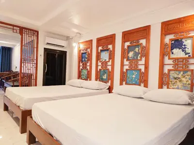 two beds in a room with paintings on the wall at Old Sрice 1 Sizzling Studio Queen Twin - No Stairs in Bangkok