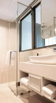 a bathroom with a sink and a mirror at The Quarter Ploenchit by UHG in Bangkok