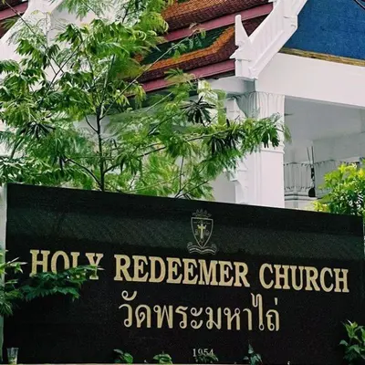 a sign for a holy redeemer church in front of a building at The Quarter Ploenchit by UHG in Bangkok