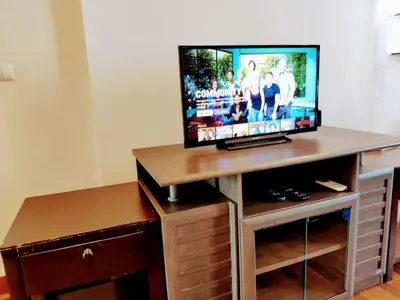 a flat screen tv sitting on top of a wooden entertainment center at Old Sрice 5 Elegant Tranquility Your BKK Haven in Bangkok