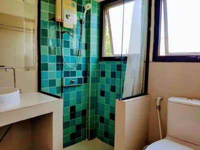a green tiled bathroom with a toilet and a shower at Old Sрice 3 Vintage Elegance in the Heart of BKK in Bangkok