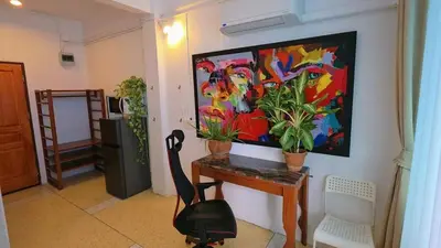 a room with a desk with a painting on the wall at Lumphini 5 Train station center EnSuite Aircon in Bangkok