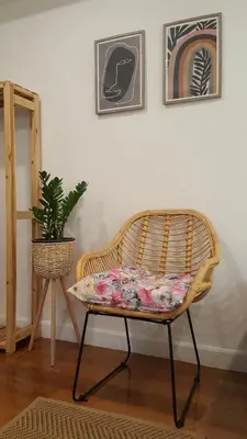 a wicker bench sitting in a room with a plant at baankorrakang in Bangkok Noi
