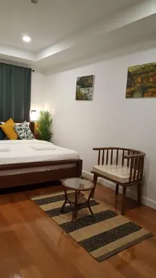 a bedroom with a bed and a bench and a table at baankorrakang in Bangkok Noi