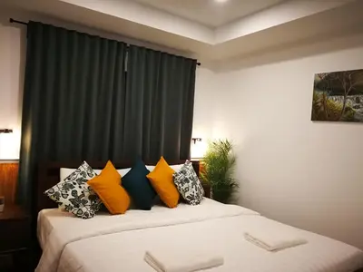 a bedroom with two beds with colorful pillows at baankorrakang in Bangkok Noi