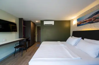a hotel room with a large white bed and a kitchen at BB Glass House บีบี กลาสเฮ้าส์ in Bangkok