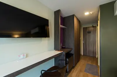 a room with a bar with a television on the wall at BB Glass House บีบี กลาสเฮ้าส์ in Bangkok