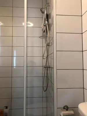 a shower with a hose in a bathroom at Chapter One Eco-Modern Suite (\u66fc\u8c37\u9ad8\u7aef\u9152\u5e97\u516c\u5bd3\uff09 in Bangkok