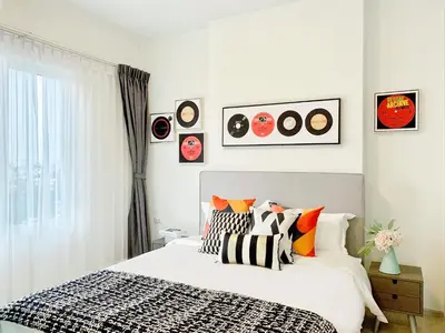 a bedroom with a bed with pillows and pictures on the wall at Chapter One Eco-Modern Suite (\u66fc\u8c37\u9ad8\u7aef\u9152\u5e97\u516c\u5bd3\uff09 in Bangkok