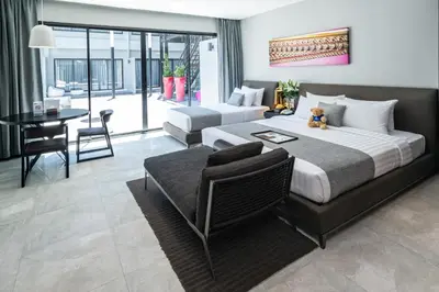 a hotel room with a large bed and a table at S Ratchada Leisure Hotel in Bangkok