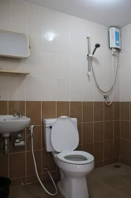 a bathroom with a toilet and a sink at Ladapan Mansion in Nonthaburi