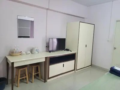 a kitchen with a desk with a tv and a cabinet at Ladapan Mansion in Nonthaburi