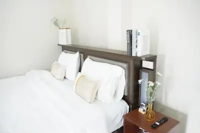 a bedroom with two beds with white pillows and a table at ATC Residence in Bang Su