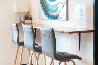 a bar with four chairs in front of a counter at ATC Residence in Bang Su