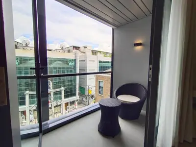 a balcony with a view of a city from a window at ashley hotel bkk in Bangkok
