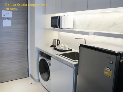 a small kitchen with a sink and a washing machine at ashley hotel bkk in Bangkok
