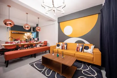 a living room with a yellow couch and a table at The Mellow at Silom in Bangkok