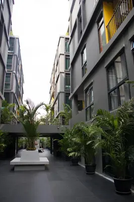 a courtyard with potted plants in front of buildings at iSanook Bangkok in Bangkok