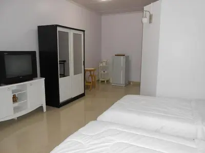 a bedroom with a bed and a tv on a cabinet at MT-Room in Bangkok