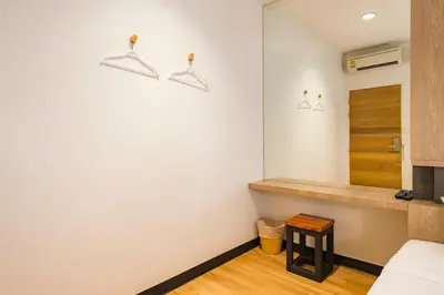 a bedroom with white walls and a wooden floor at T Hostel @ Victory Monument in Bangkok