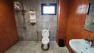 a bathroom with a toilet and a sink and a shower at Krung Boutique Hotel in Bangkok