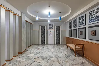 a hallway with a bench and paintings on the walls at The Wing Design Hotel in Bangkok