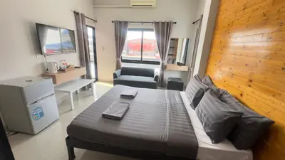 a bedroom with a bed and a chair in it at Buathong Pool Villa in Ban Khung Taphao
