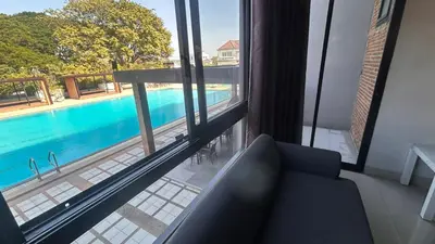 a living room with a view of a swimming pool at Buathong Pool Villa in Ban Khung Taphao