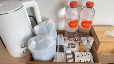 a wooden tray with two bottles of water and other items at Buathong Pool Villa in Ban Khung Taphao