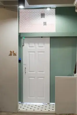 a white door in a room with a sign above it at Bangpho Story in Bangkok