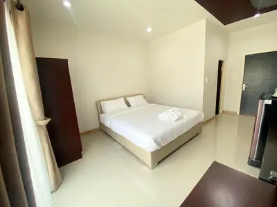 a bedroom with a white bed in a room at Re Riva in Ban Bang Bamru