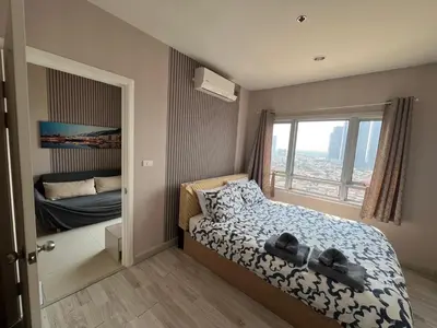 a small bedroom with a bed and a window at river front in Nonthaburi