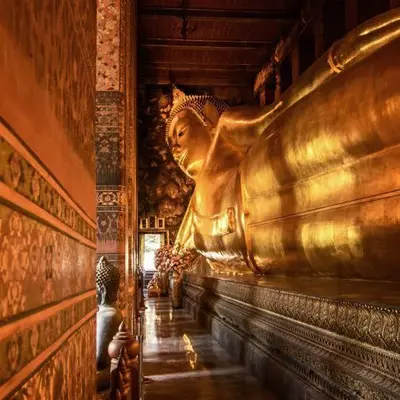 a large golden statue in a room with a wall at U&D guest house in Bangkok
