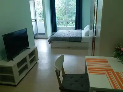 a living room with a television and a bed at DD Garden Apartment 2 in Bangkok