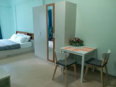 a bedroom with a bed and a table and chairs at DD Garden Apartment 2 in Bangkok