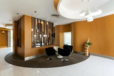 a lobby with black chairs and wooden walls at Royal Delight Hotel in Bangkok