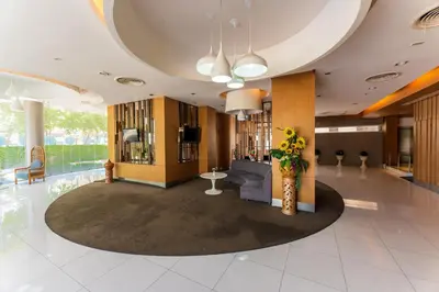 a lobby with a couch and a vase of flowers at Royal Delight Hotel in Bangkok