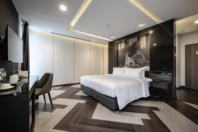 a hotel room with a bed and a desk and a desk at VIX Bangkok at Victory Monument in Bangkok