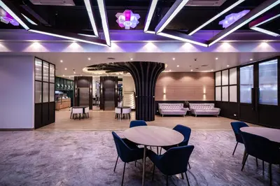 a lobby with tables and chairs in a building at VIX Bangkok at Victory Monument in Bangkok