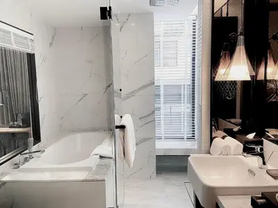 a white bathroom with a tub and a sink at Homm Sukhumvit34 Bangkok in Bangkok