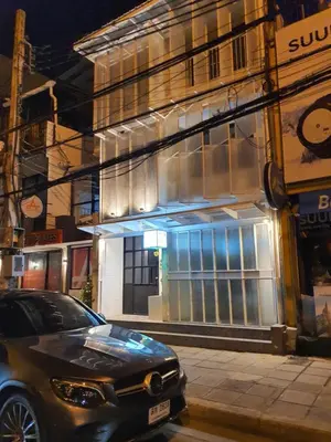 a black car parked in front of a building at Roompini in Bangkok