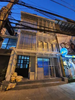 a white building with a door and windows at Roompini in Bangkok